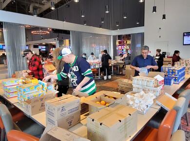 Volunteers sort and pack food relief packages.